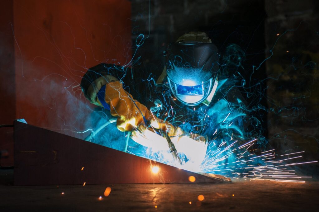 A man at welding work wearing protection. jacket and helmet