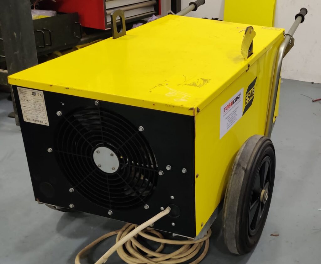 Yellow ESAB welding machine with wheels and power cord.