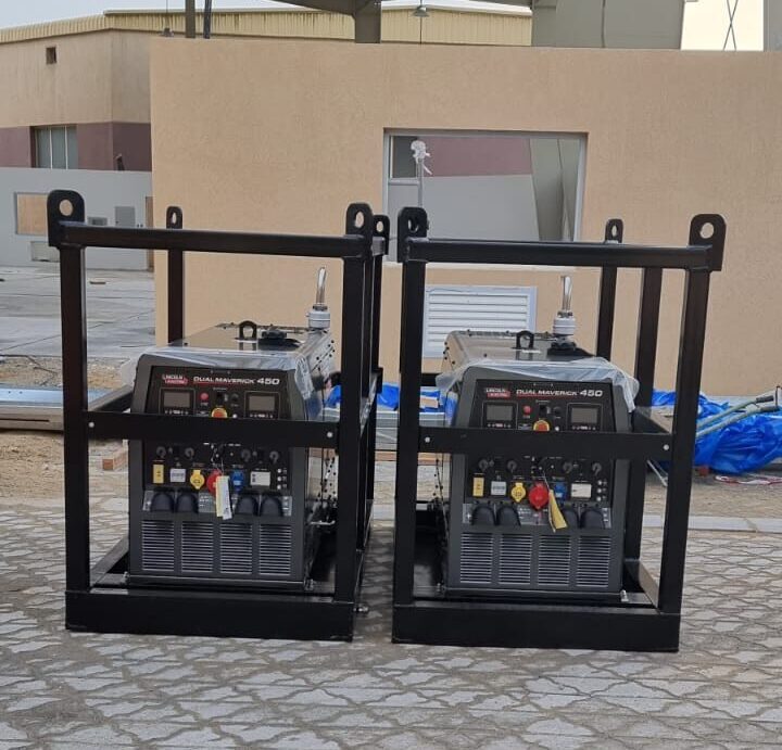 Two industrial Lincoln Dual Maverick 450 welding generators housed in metal frames, placed outdoors on a paved surface.