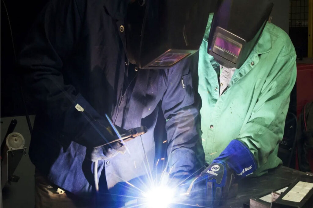 Two welders working with welding torch.