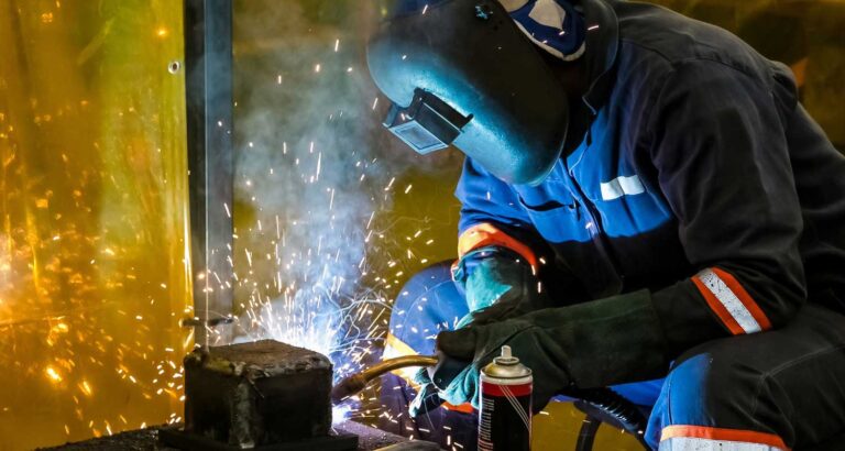 A man at welding work wearing protection. jacket and helmet