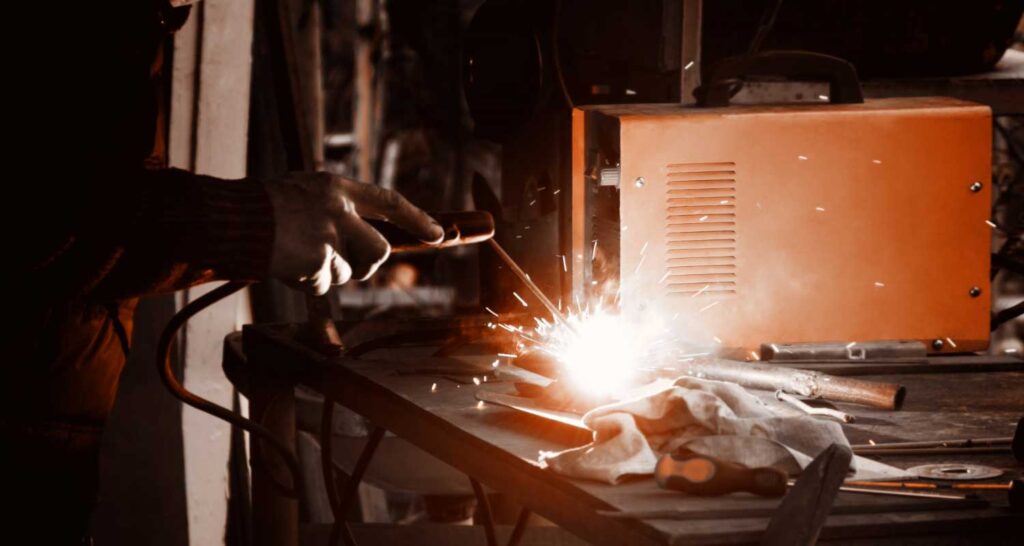 Man welding old shovel, close up.