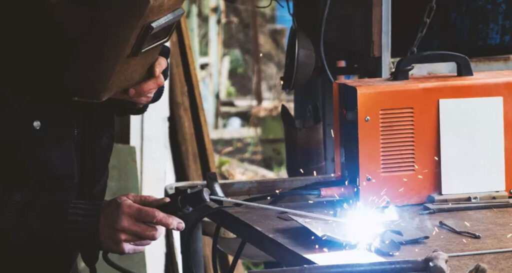 Man welding old shovel, close up.